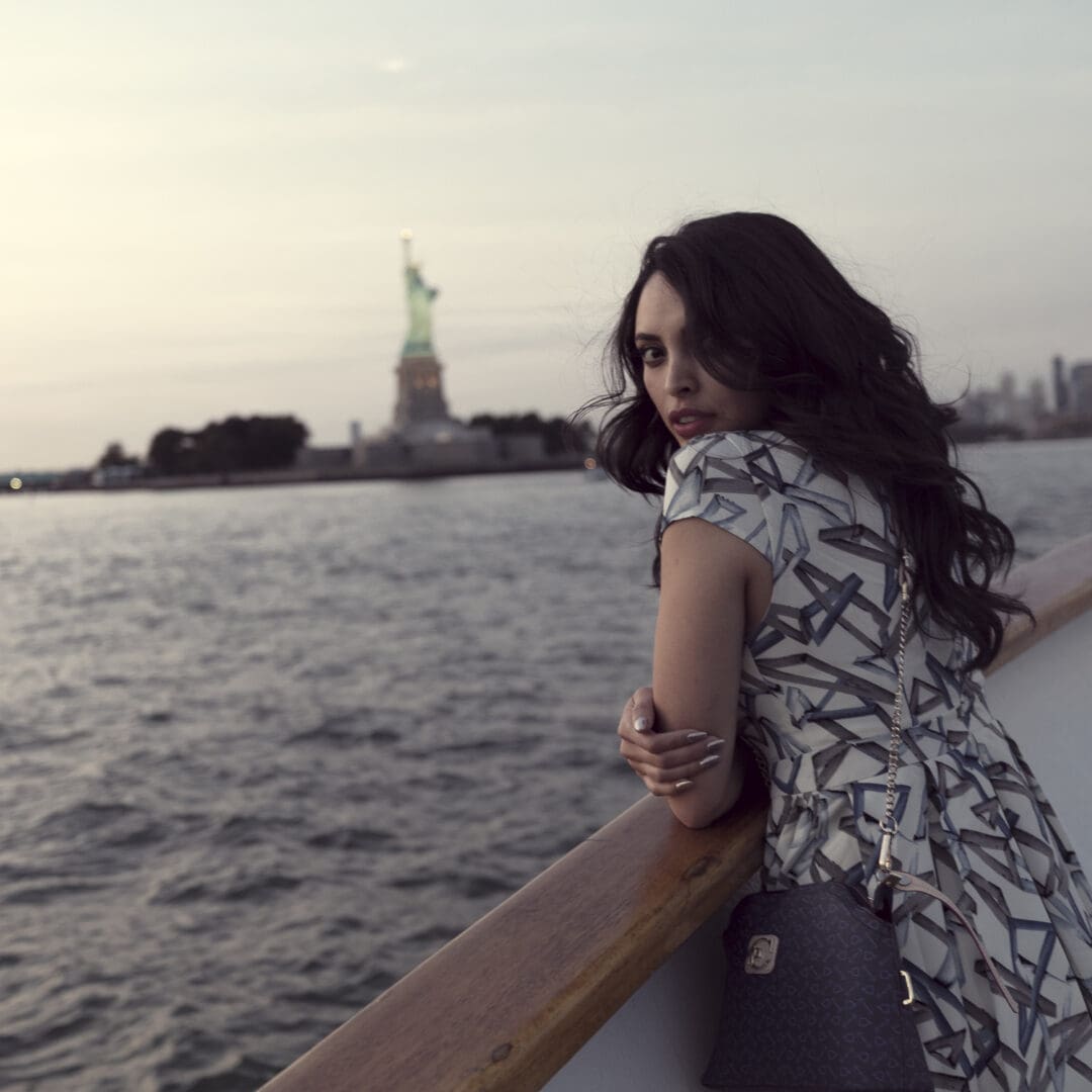 A Woman Posing Near Statue of Liberty